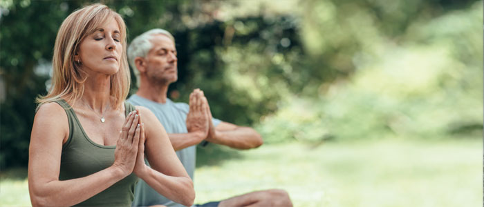 Woman and man meditationg outside